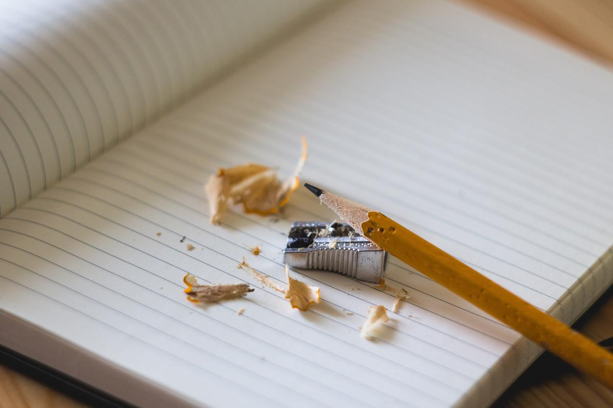 Cuaderno de líneas en blanco con un lápiz, un sacapuntas y virutas